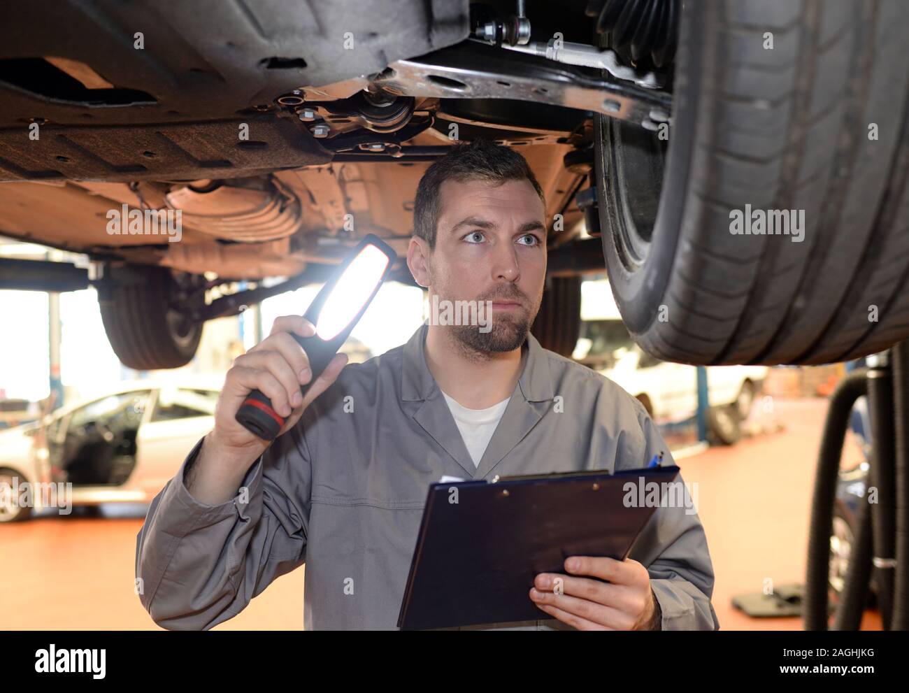 Mechaniker in der Werkstatt überprüft und inspiziert ein Fahrzeug für Mängel Stockfoto