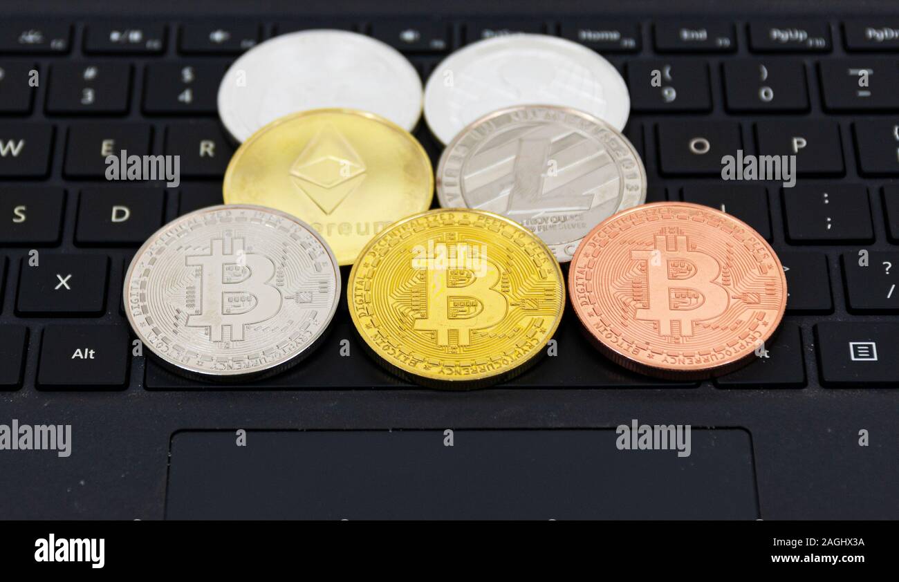 Cryptocurrency Münzen Bitcoin, Litecoin, des Astraleums und Welligkeit, auf einem Schwarz Computer Tastatur platziert. Stockfoto