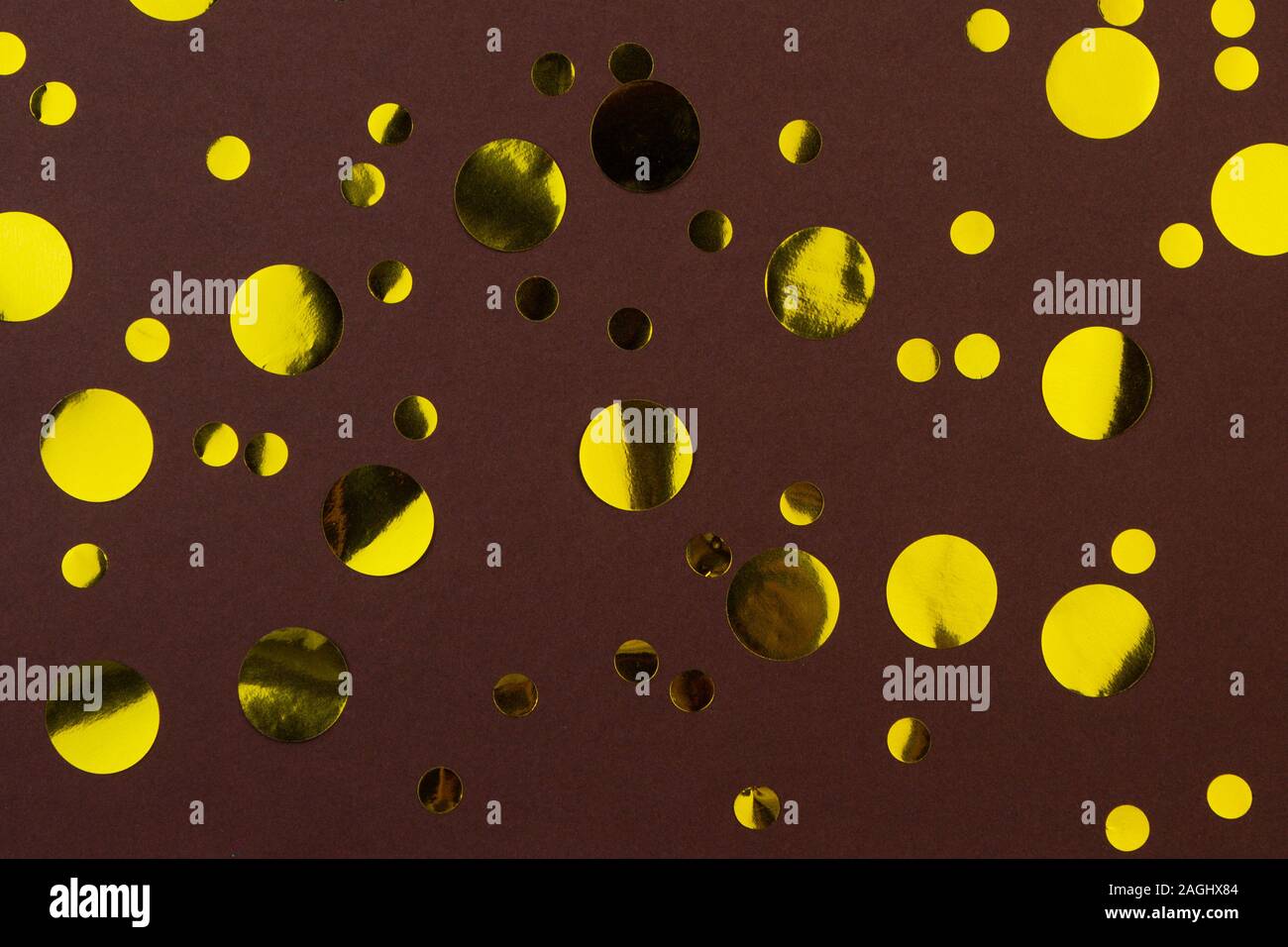 Gelb Gold Metallic Konfetti Punkte auf braunen Hintergrund. Stockfoto