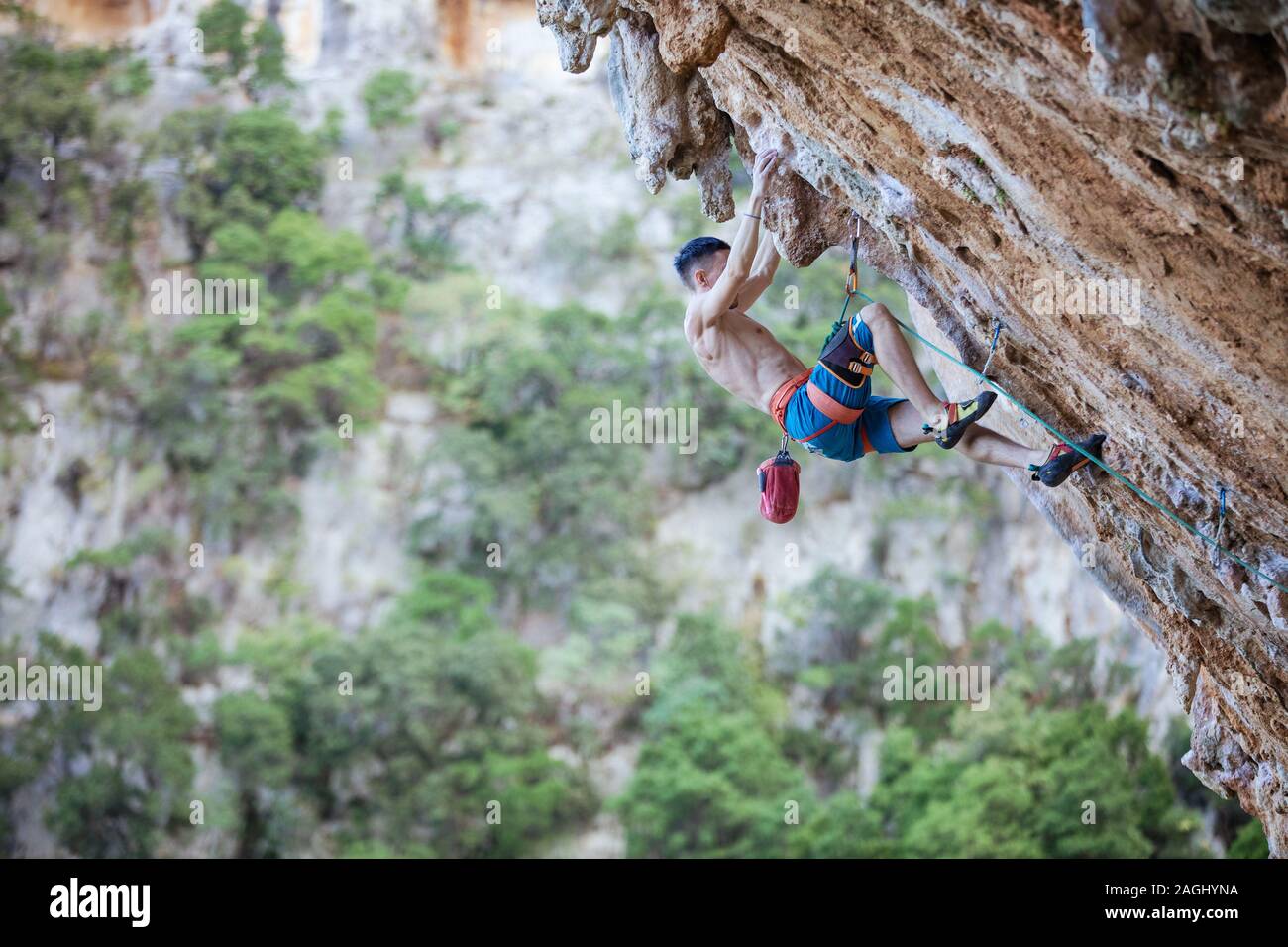 Junge männliche Kletterer auf anspruchsvolle Route auf überhängenden Klippe Stockfoto