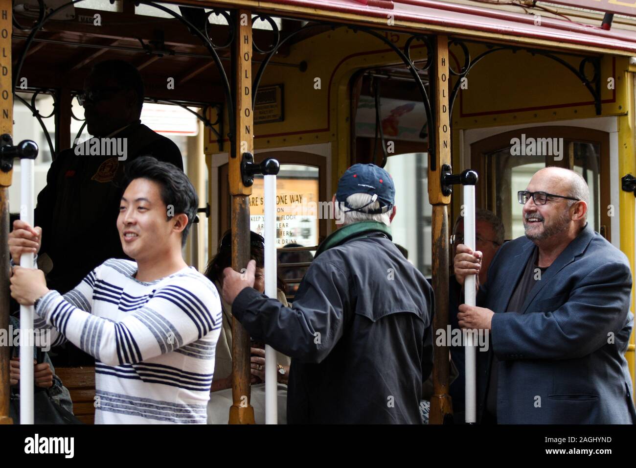 Touristen Festhalten am Cable Car Pol an der Powell Street Turnaround in San Francisco, Vereinigte Staaten von Amerika Stockfoto