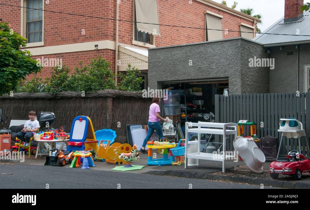 Mutter und Sohn mit Überschuss Spielzeug an Ihrer Garage oder Yard Sale im Vorort Elwood, Melbourne, Australien Stockfoto
