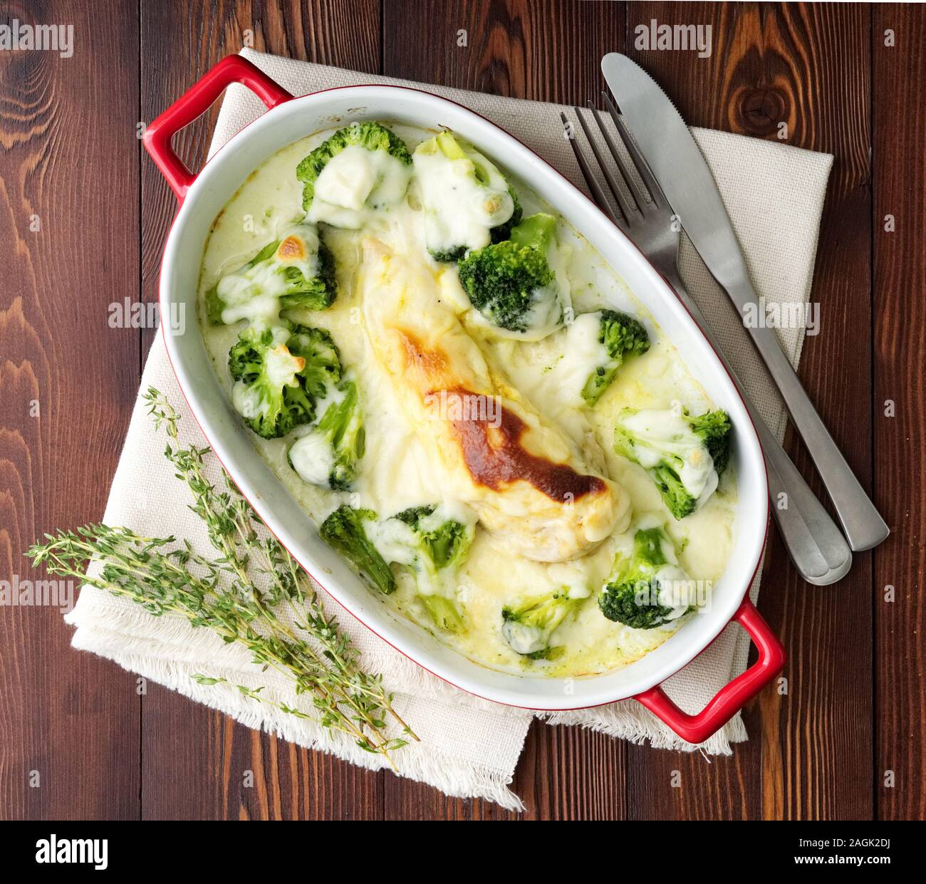 Hähnchenbrustfilet überbacken mit Broccoli in bechamelsauce Soße auf einem dunklen Holztisch. Gesunde Nahrung, sauberes Essen, Ansicht von oben. Stockfoto