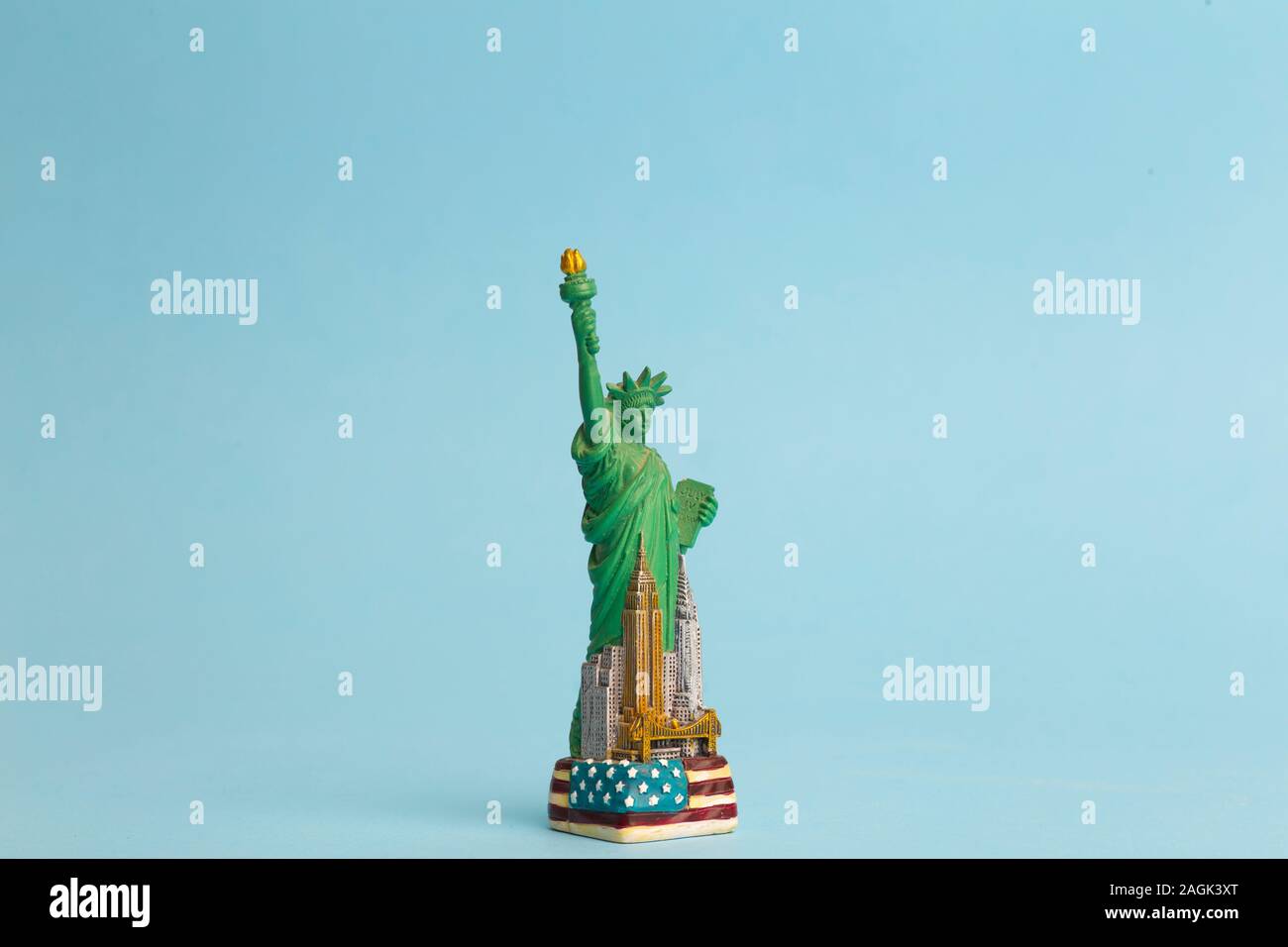 Freiheitsstatue auf einem blauen Hintergrund reinigen. Spielzeug Modell der Freiheitsstatue als Mitbringsel von einer Reise in die USA. Stockfoto