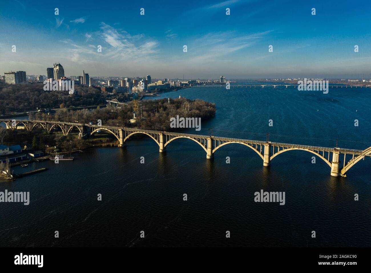 Antenne Panoramaaussicht auf alten arch Eisenbahn Merefo-Kherson Brücke über den Fluss Dnepr in Dnipropetrowsk. Blick auf dem rechten Ufer des Dnipro. Stockfoto
