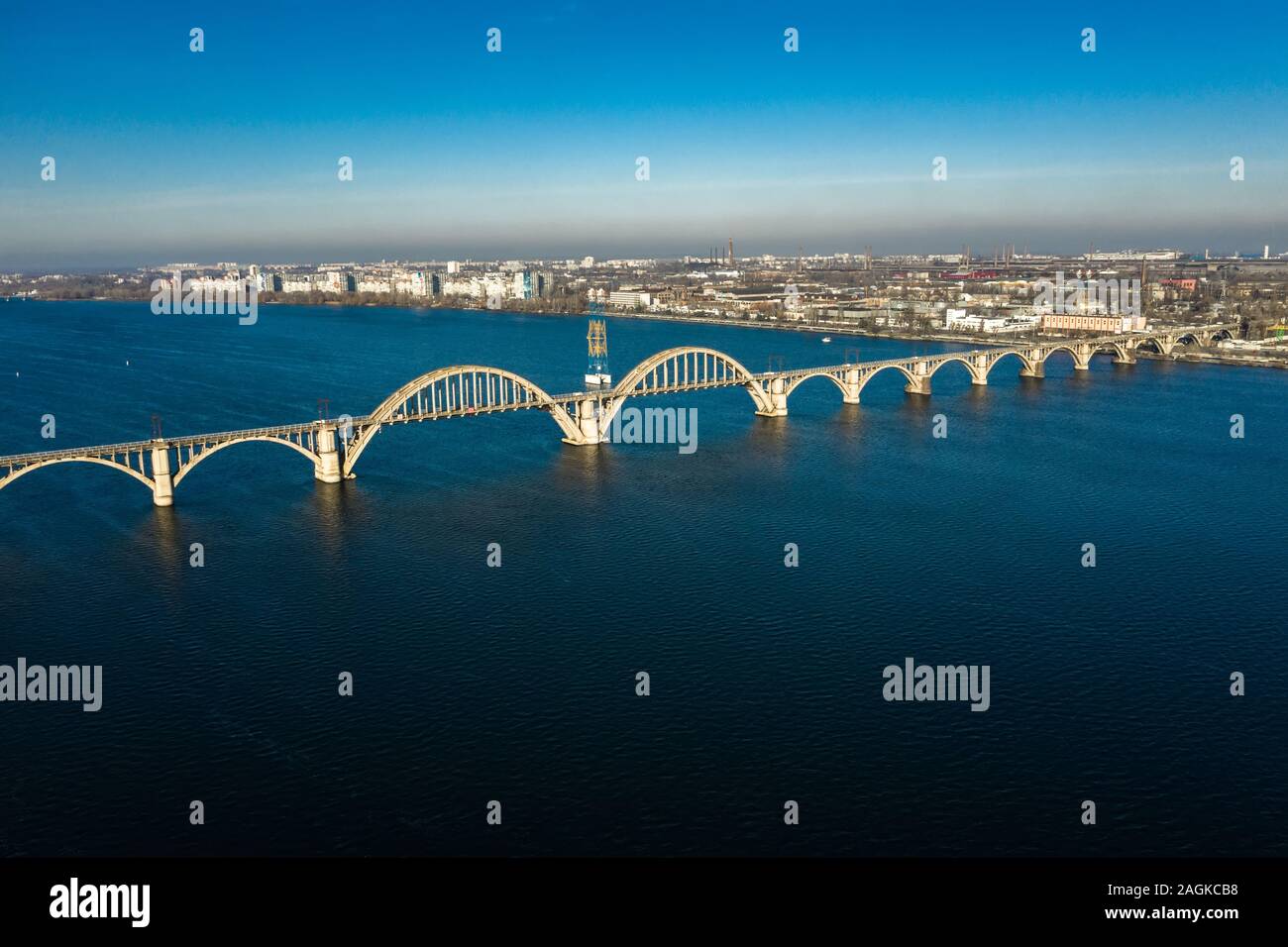 Antenne Panoramaaussicht auf alten arch Eisenbahn Merefo-Kherson Brücke über den Fluss Dnepr in Dnipropetrowsk. Blick auf das linke Ufer des Dnipro. Stockfoto