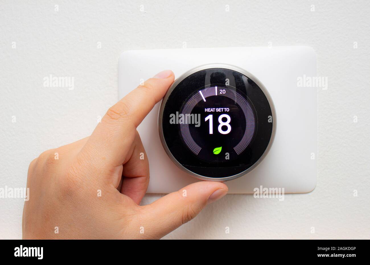 Smart Thermostat mit einer Person Energie sparen mit einem weichen Schatten Stockfoto