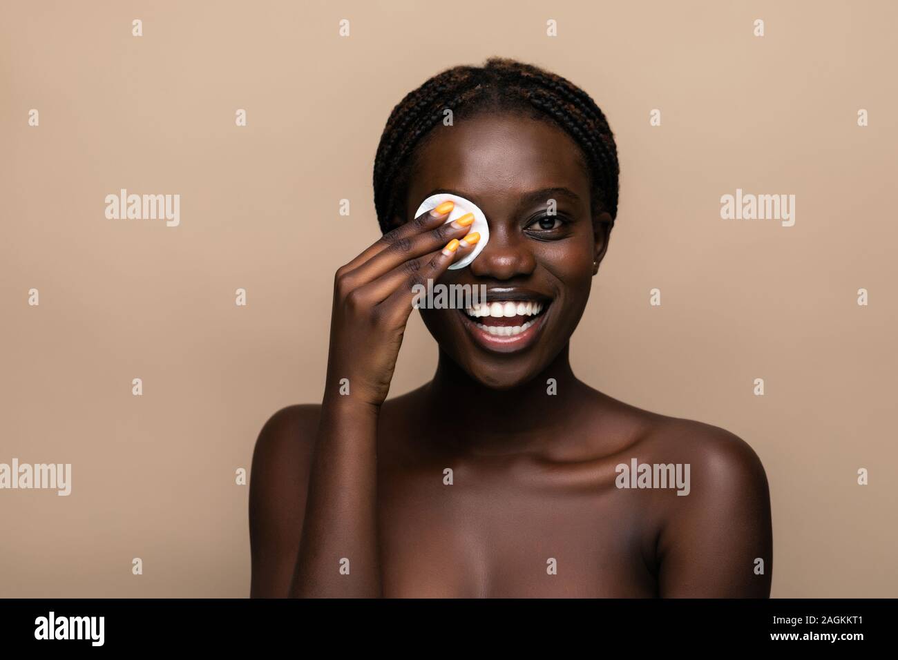 Porträt einer attraktiven afroamerikanische Frau entfernen Make-up mit Schwamm hautnah Stockfoto