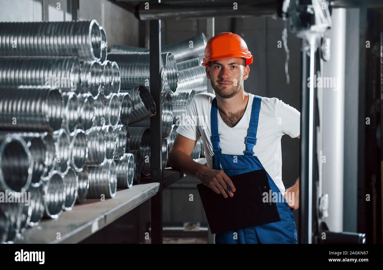 Eine Auszeit nimmt. Mann in Uniform Werke auf die Produktion. Die industrielle moderne Technologie Stockfoto