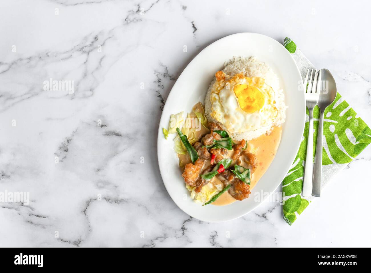 Cremige gesalzene Ei gebratenes Huhn mit Reis und Ei. Asien Essen auf dem Tisch. Flach von oben nach unten anzeigen. Stockfoto