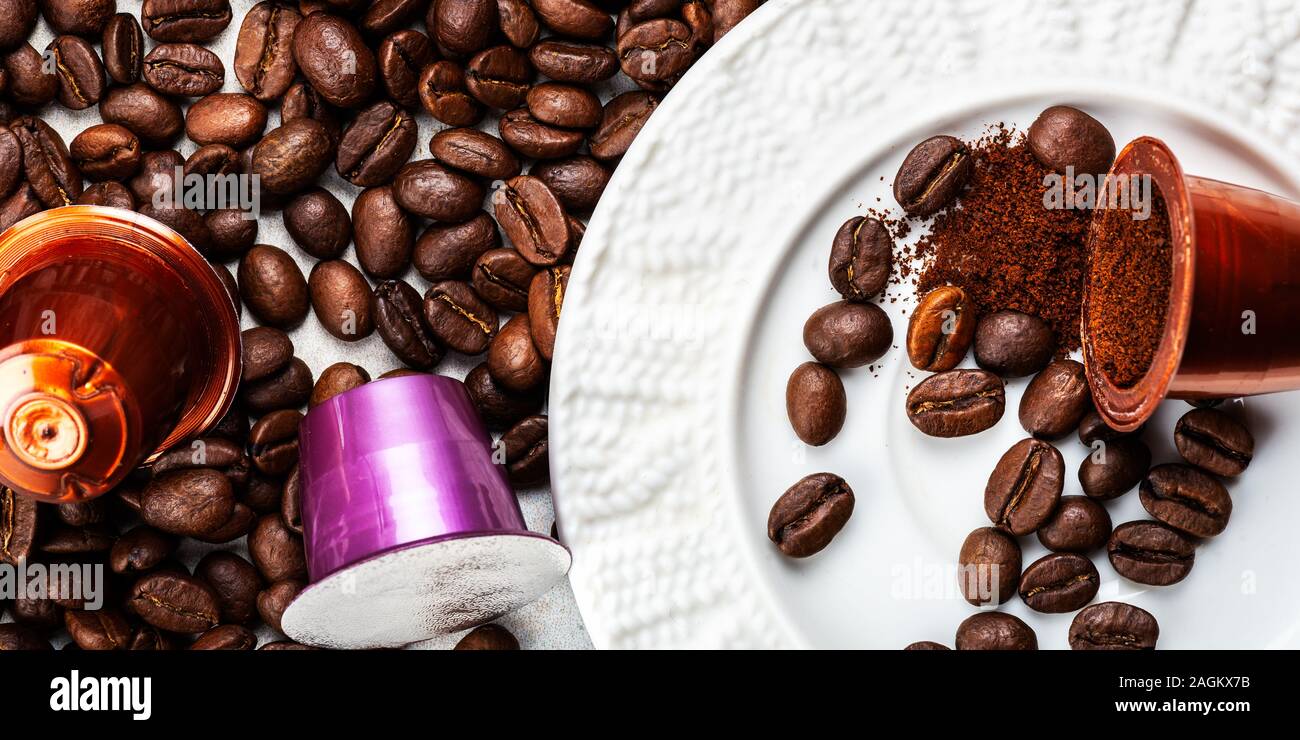 Öffnen Espresso Kaffee Kapseln oder Hülsen und Kaffeebohnen auf grauem Hintergrund, Ansicht von oben. Die Zubereitung von Kaffee zu Hause Konzept. Stockfoto
