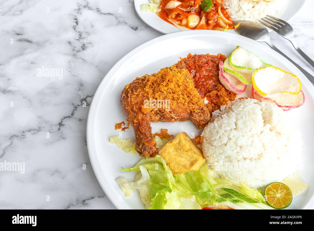 Ayam Penyet ist Indonesisch Osten javanische Küche - bestehend aus gebratenes Huhn, das mit dem Mörser gegen Mörtel zertrümmert ist es weicher zu machen, serviert. Stockfoto