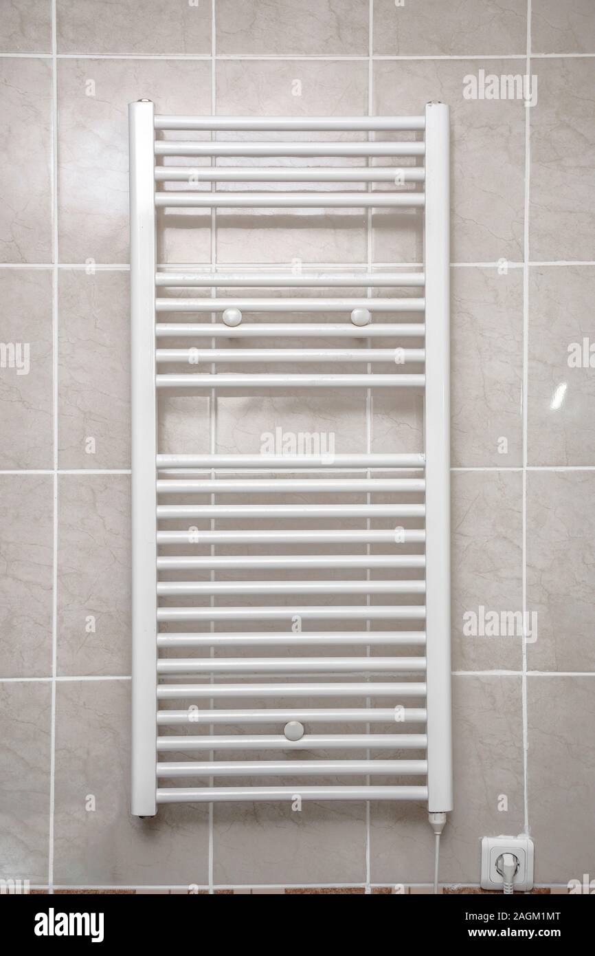 Edelstahl elektrischen Handtuchtrockner für das Badezimmer. Die Trocknung  ist mit Fliesen an der Wand montiert. Handtuch Trockner zum Trocknen von  Handtüchern im Badezimmer Stockfotografie - Alamy