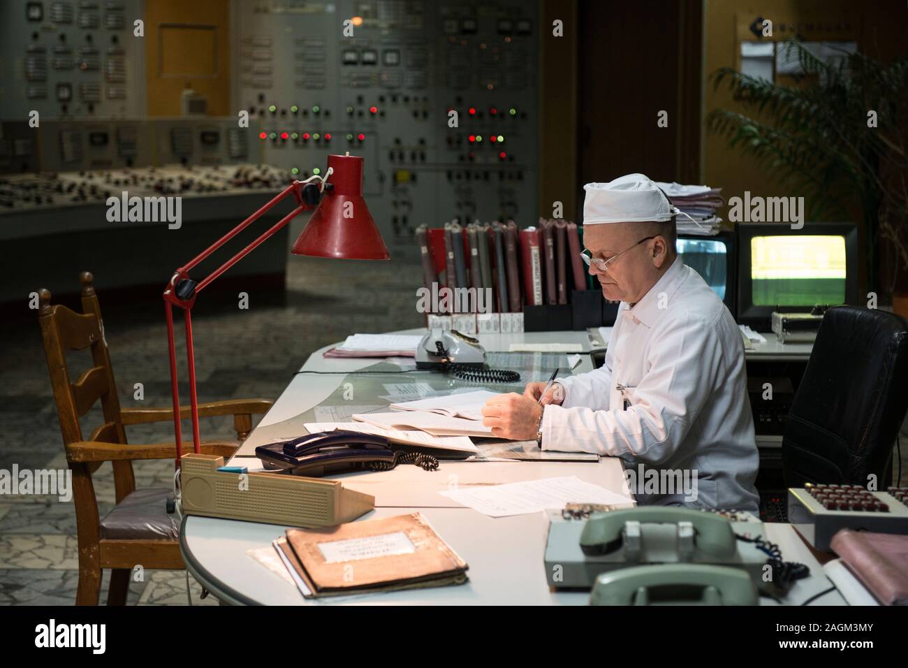 Ein Mitarbeiter des Kernkraftwerks Tschernobyl Arbeiten im Kontrollraum des Reaktors 2 des Kernkraftwerks Tschernobyl. Die Zimmer hat seinen ursprünglichen Displays und Panels der Schaltflächen. Kernkraftwerk Tschernobyl, Tschernobyl, Ivankiv Rajon, Oblast Kiew, Ukraine, Europa Stockfoto