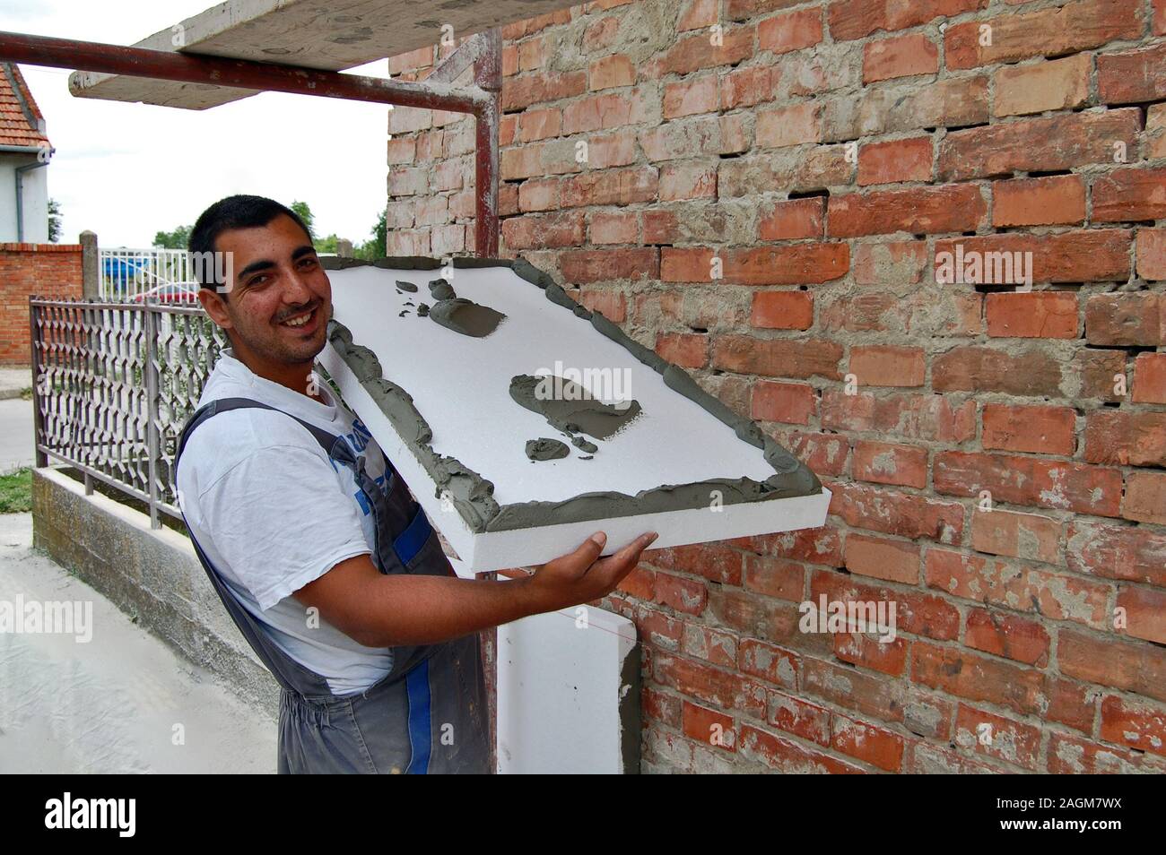 Zrenjanin, Serbien, 29.Juni 2013. Klebeband Styropor an der Wand Fassade Arbeitnehmer. Gebäudeisolierung spart Energie. Stockfoto