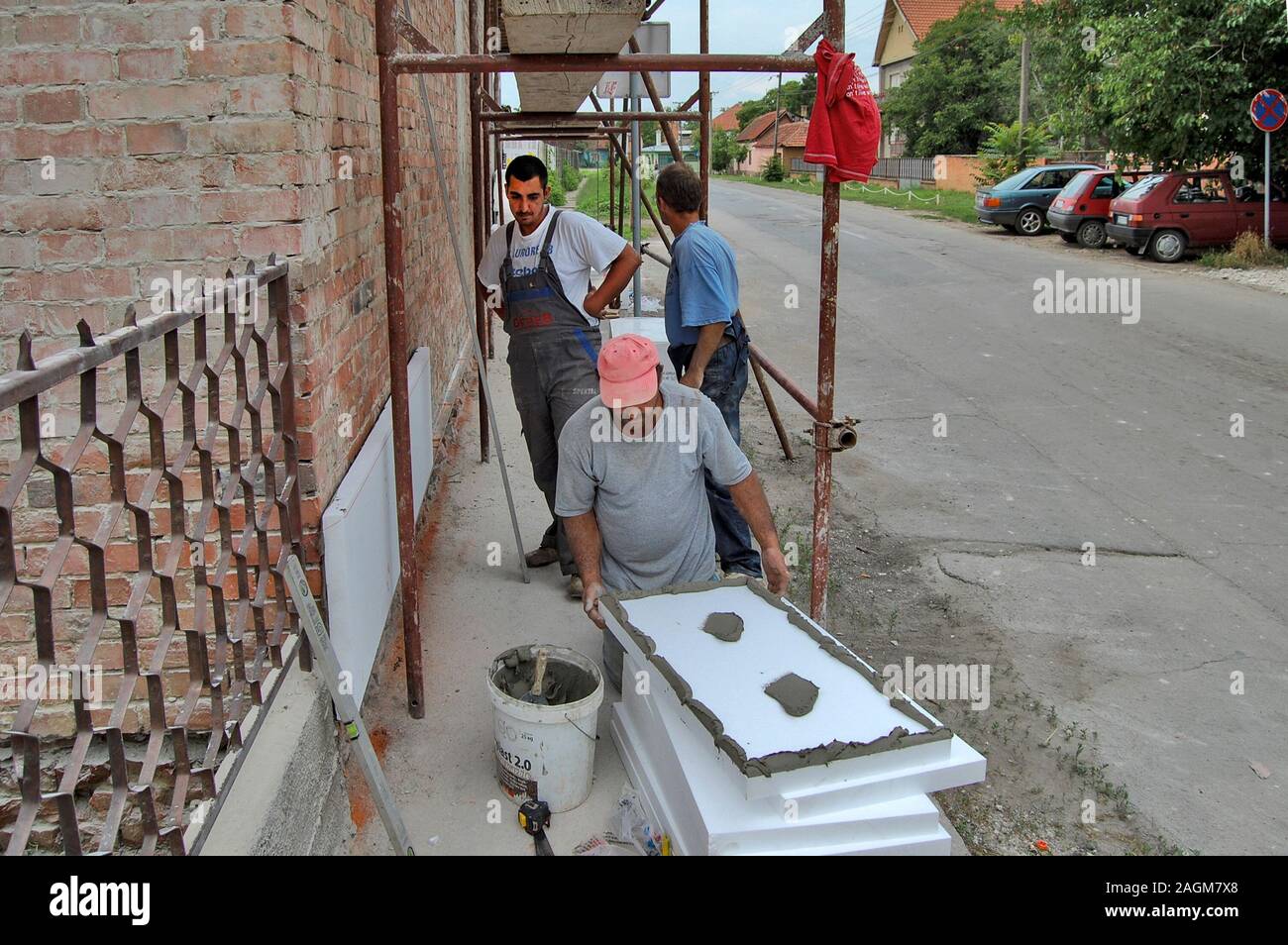 Zrenjanin, Serbien, 29.Juni 2013. Klebeband Styropor an der Wand Fassade Arbeitnehmer. Gebäudeisolierung spart Energie. Stockfoto