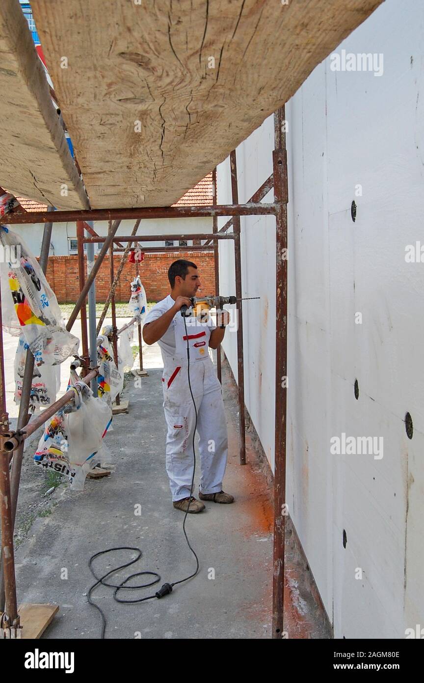 Zrenjanin, Serbien, 29. Juni 2013. Styropor bohren für die Fassade zur Festsetzung. Die Einhaltung Styropor an der Wand verbessert die Isolierung des Gebäudes. Buildi Stockfoto