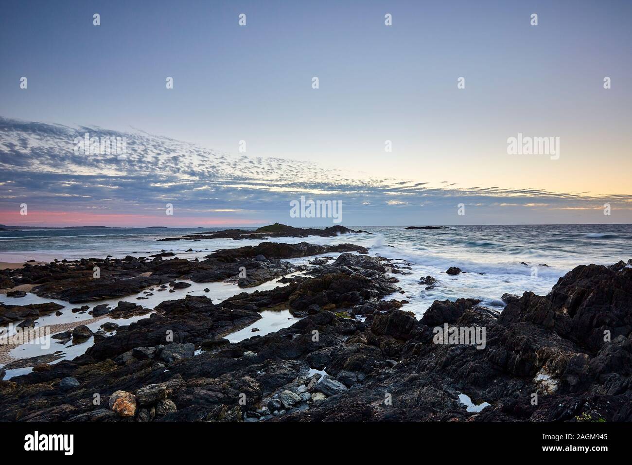 Der Beginn des Sonnenaufgangs mit der Sonne unter dem Horizont an der Küste von Sawtell mit Blick auf den Pazifischen Ozean, New South Wales, Australien Stockfoto