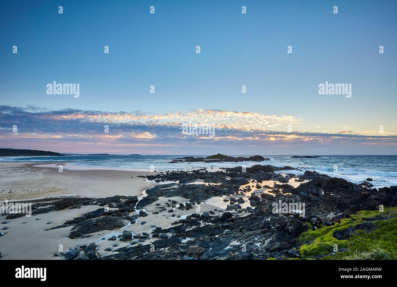 Der Beginn des Sonnenaufgangs mit der Sonne unter dem Horizont an der Küste von Sawtell mit Blick auf den Pazifischen Ozean, New South Wales, Australien Stockfoto