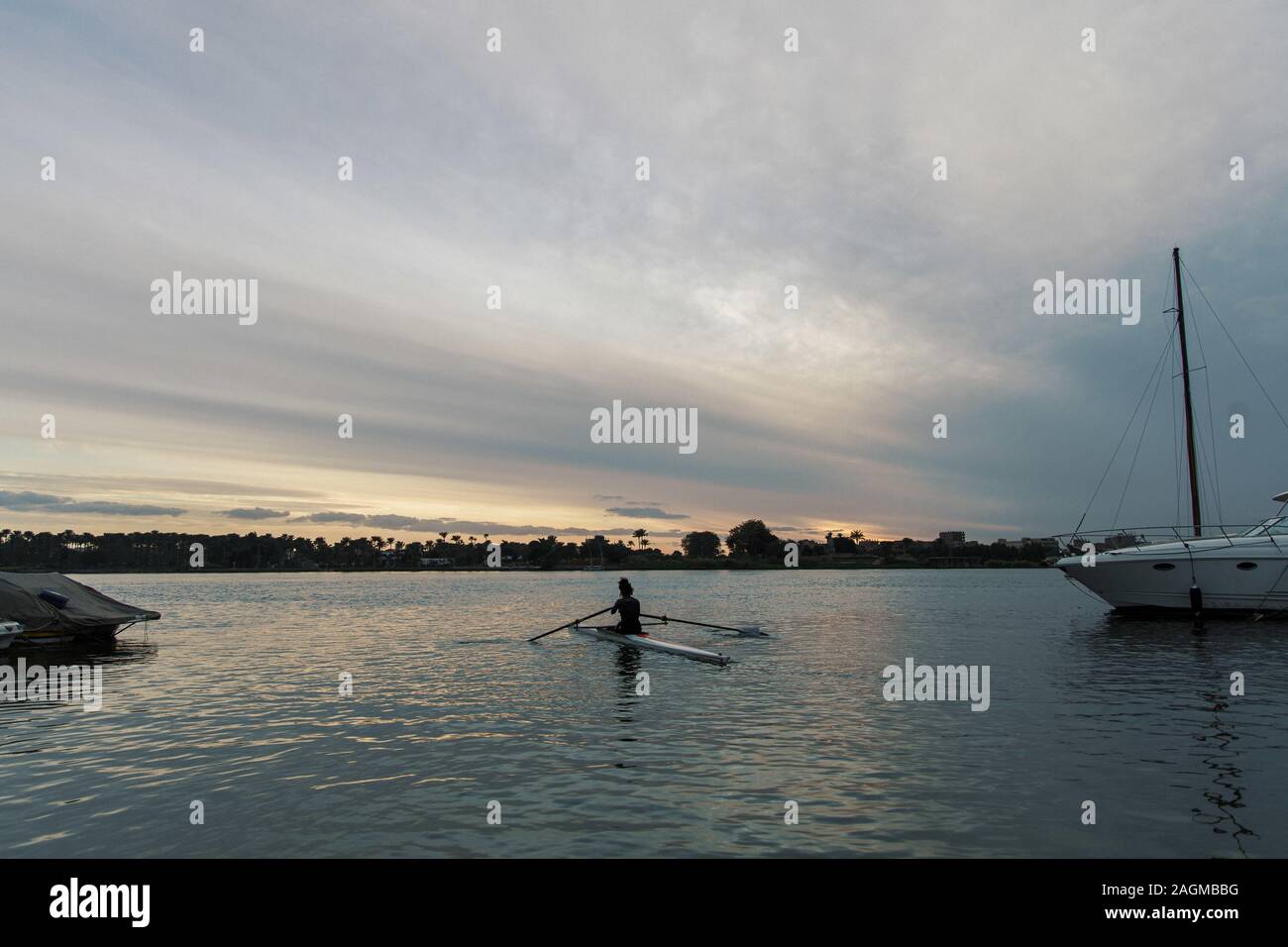 Weibchen in einem Kanu paddeln im Wasser unter einem wolkiger Himmel Stockfoto