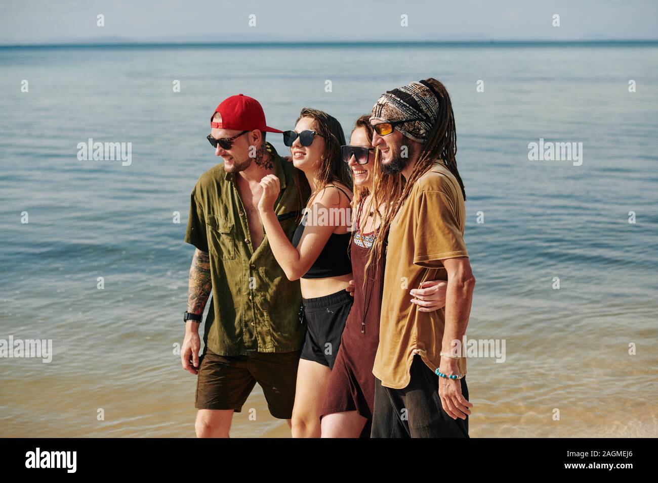 Zwei glückliche Paare Ausgaben umarmen Urlaub am Meer und Wandern am Strand zusammen Stockfoto