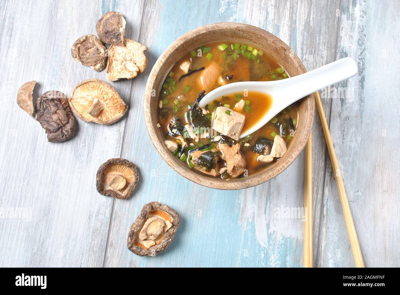 Japanische Miso-Suppe mit frischem Thunfisch, getrockneten Algen, Tofu, Shiitake getrockneten Pilzen in einer Holzschüssel auf dem Holzhintergrund Stockfoto