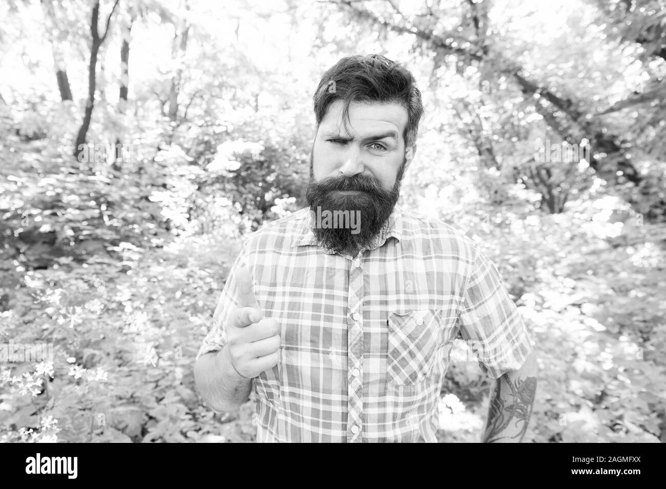 Hey, sieh. Bärtiger Mann Zeigefinger vor ihm auf natürliche Landschaft. Brutale hipster zeigt mit dem Zeigefinger auf Kamera. Caucasain Kerl zeigt auf etwas. So zeigen Geste. Stockfoto