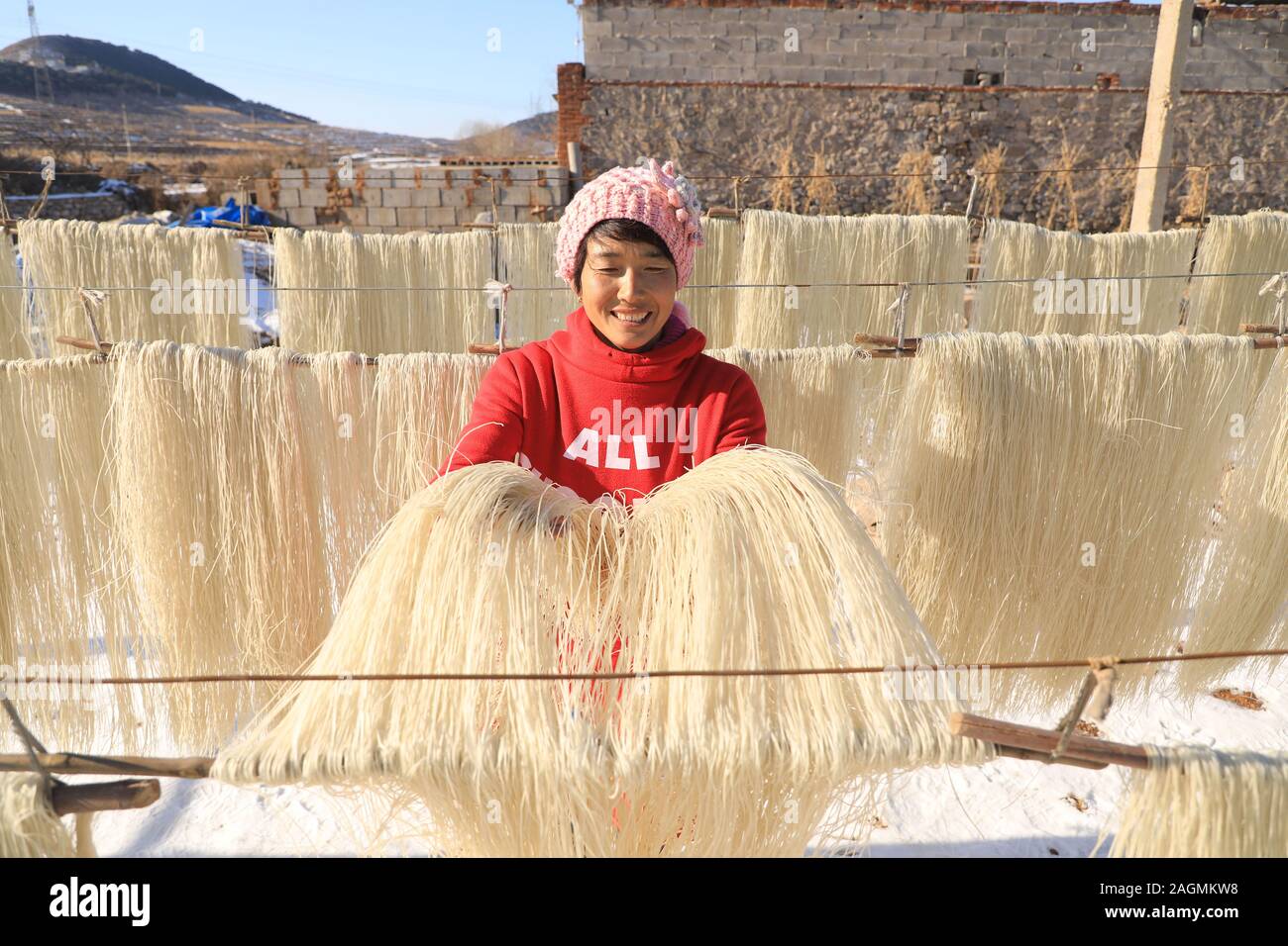 Tangshan, Provinz Hebei Provinz Chinas. 20 Dez, 2019. Ein Dorfbewohner trocknet Vermicelli an Xizhuyu Dorf Huoshiying County im Norden Chinas Tangshan, Provinz Hebei, Dez. 20, 2019. Die Landwirte von Xizhuyu Dorf sind damit beschäftigt, die VERMICELLI die Nachfrage des Marktes zu treffen und mehr Geld während der Durchhang Winter Saison gewinnen. Credit: Mu Yu/Xinhua/Alamy leben Nachrichten Stockfoto