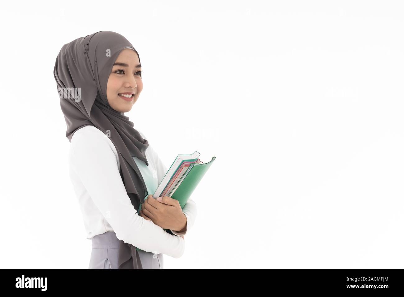 Portrait von gut aussehenden Glückliche junge erwachsenen Muslim islamische asiatische Universität Frau mit bunten Buch. Studio shot auf weißem Hintergrund. Stockfoto