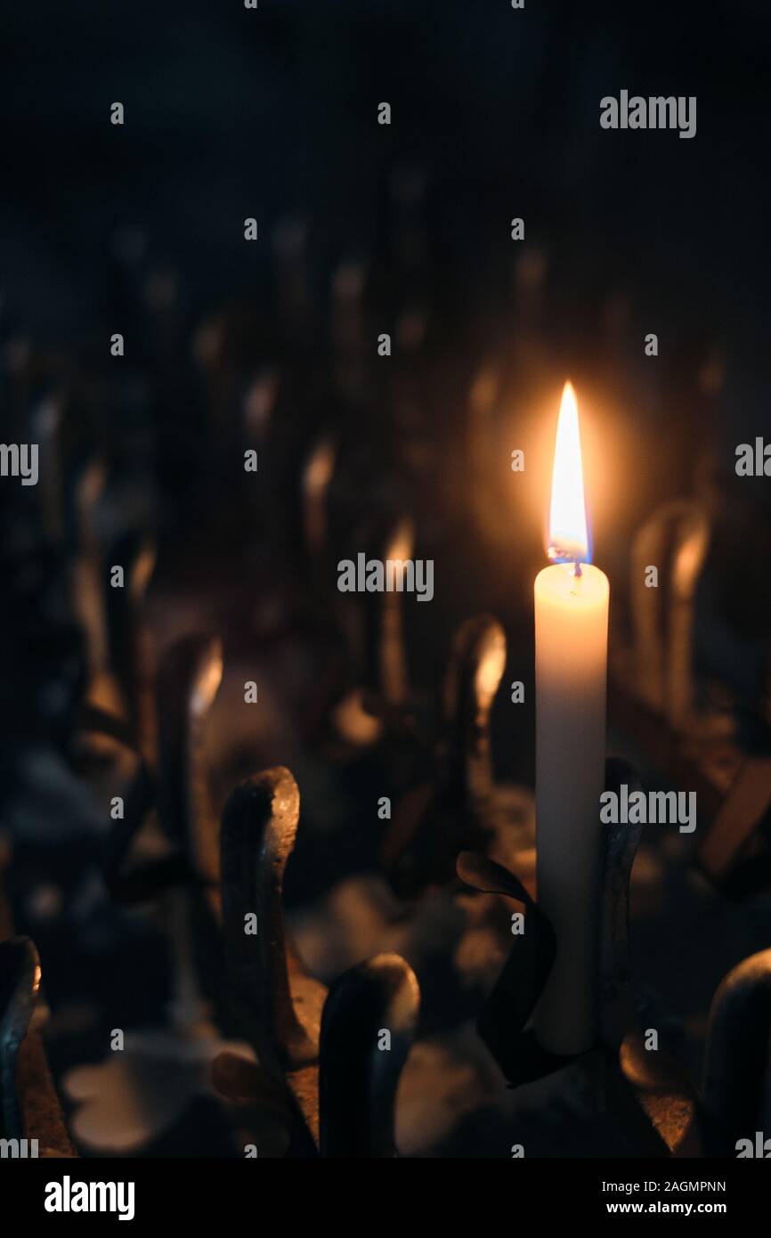Eine einzige beleuchtete Votiv oder Gebet Kerze in einer katholischen Kirche - denken an jemanden Stockfoto