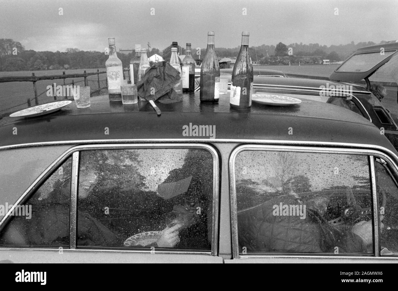 Schlechtes Wetter UK 1980er Jahre Menschen sitzen in ihrem Auto, halten sich aus dem Regen im Cowdray Park Polo Club 1981. Ein nasses Picknick im Freien während der Mittagspause des Polo-Spiels. HOMER SYKES Stockfoto