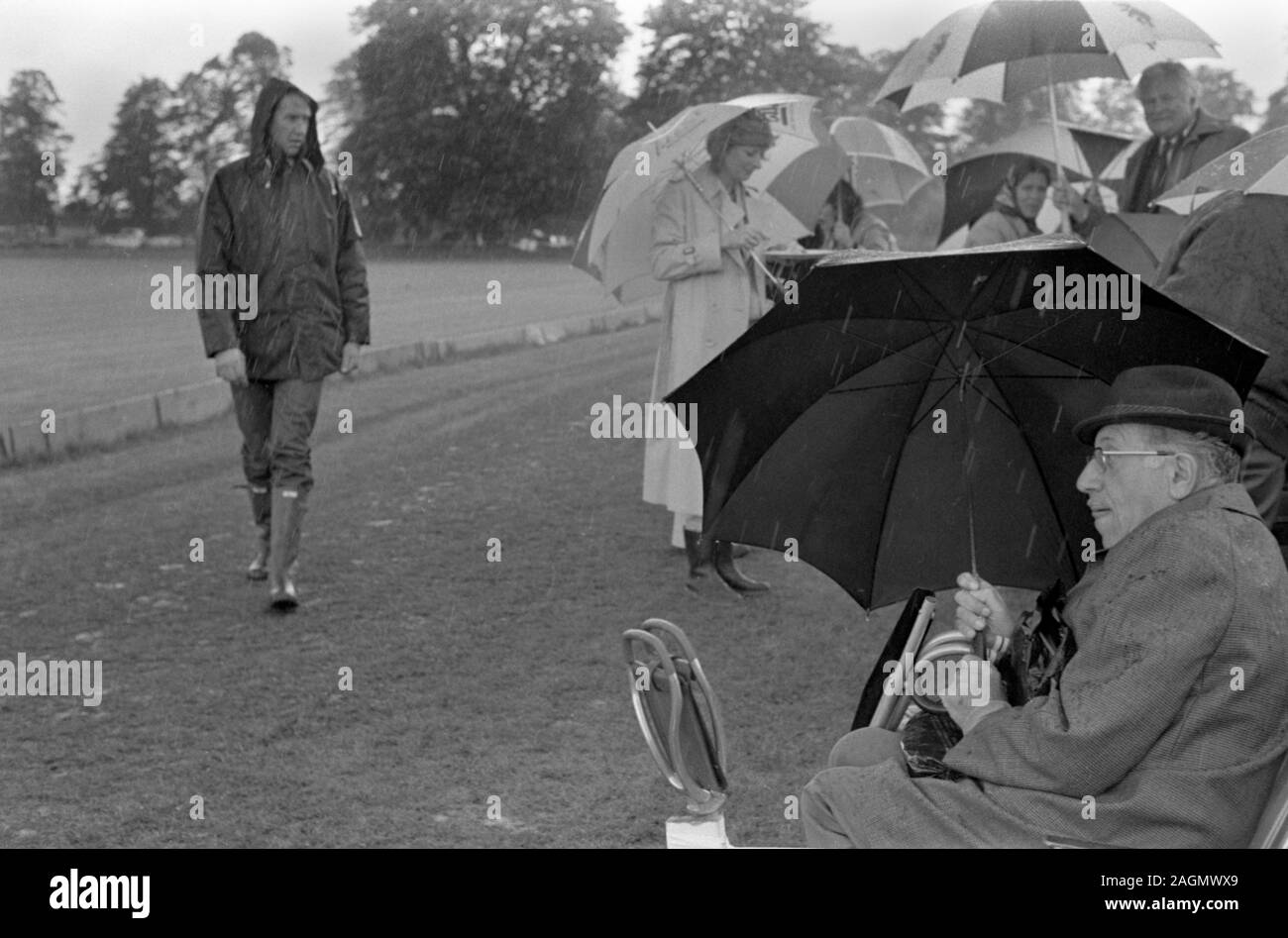 Schlechtes Wetter UK 80er Jahre Menschen im Cowdray Park Polo Club 1981 immer nass Alfresco Picknick während der Mittagspause England. HOMER SYKES Stockfoto