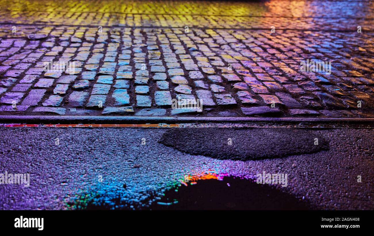 Nasse Fahrbahn spiegeln Neon Licht von einem Jahrmarkt bei Nacht Stockfoto