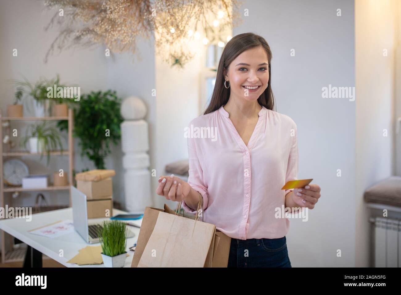 Freudige schöne Frau ihre Einkaufstaschen Holding Stockfoto