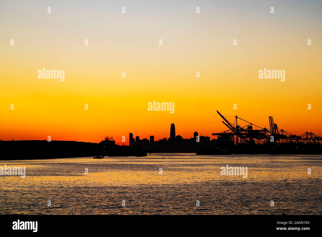 Sonnenuntergang über der Skyline von San Francisco und Oakland Hafen. Kalifornien, Vereinigte Staaten von Amerika Stockfoto