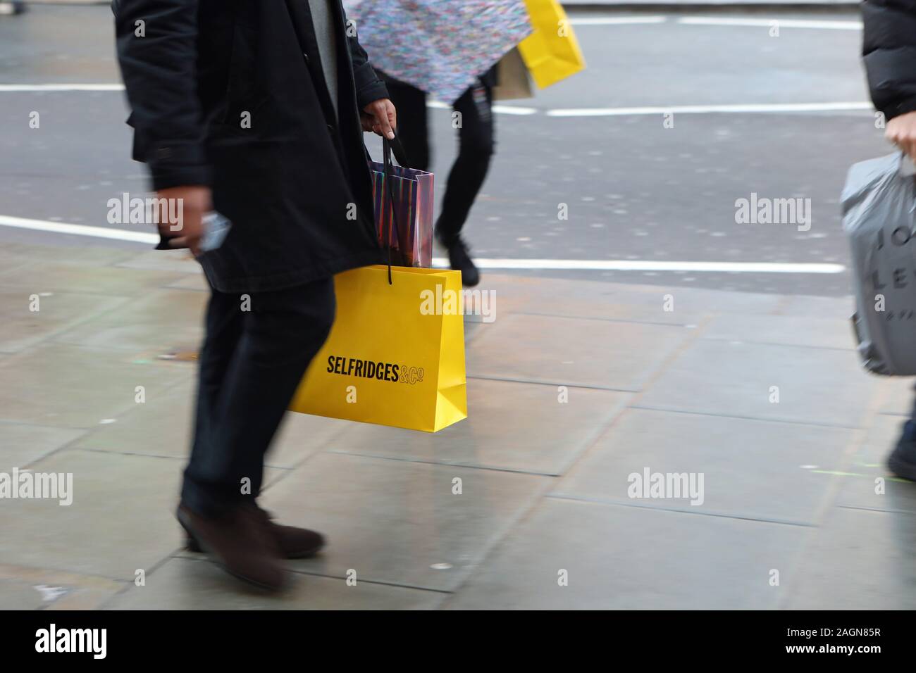 Eine Person trägt eine Selfridges Beutel in der Oxford Street in London, am letzten Freitag vor Weihnachten. Stockfoto