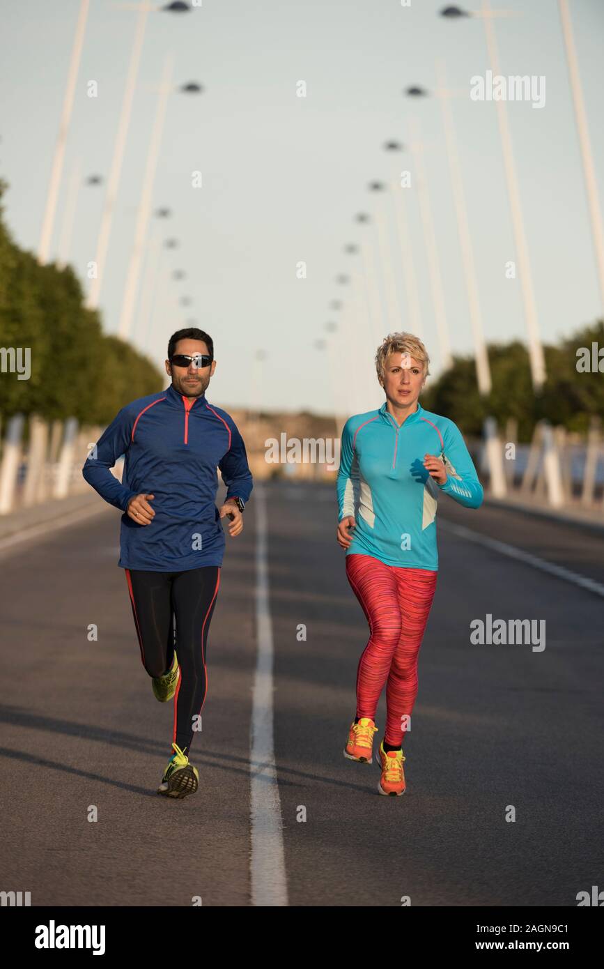 Zwei glückliche Athleten Joggen auf der Straße der Stadt, Alicante, Spanien Stockfoto