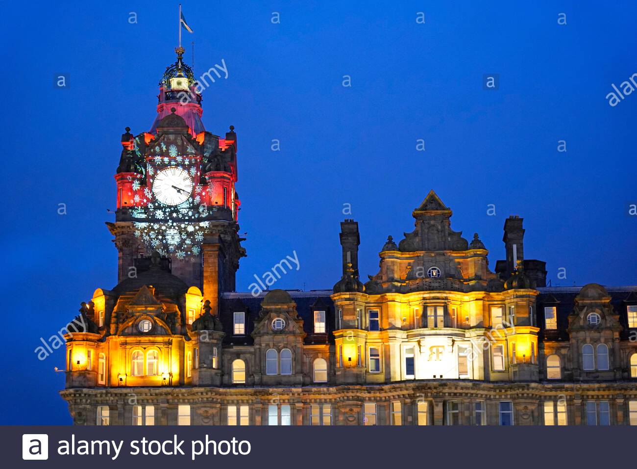Edinburgh, Schottland, Großbritannien. 20. Dez 2019. Balmoral Hotel Uhr beleuchtet mit Weihnachten Schneeflocken in der Abenddämmerung. Quelle: Craig Brown/Alamy leben Nachrichten Stockfoto