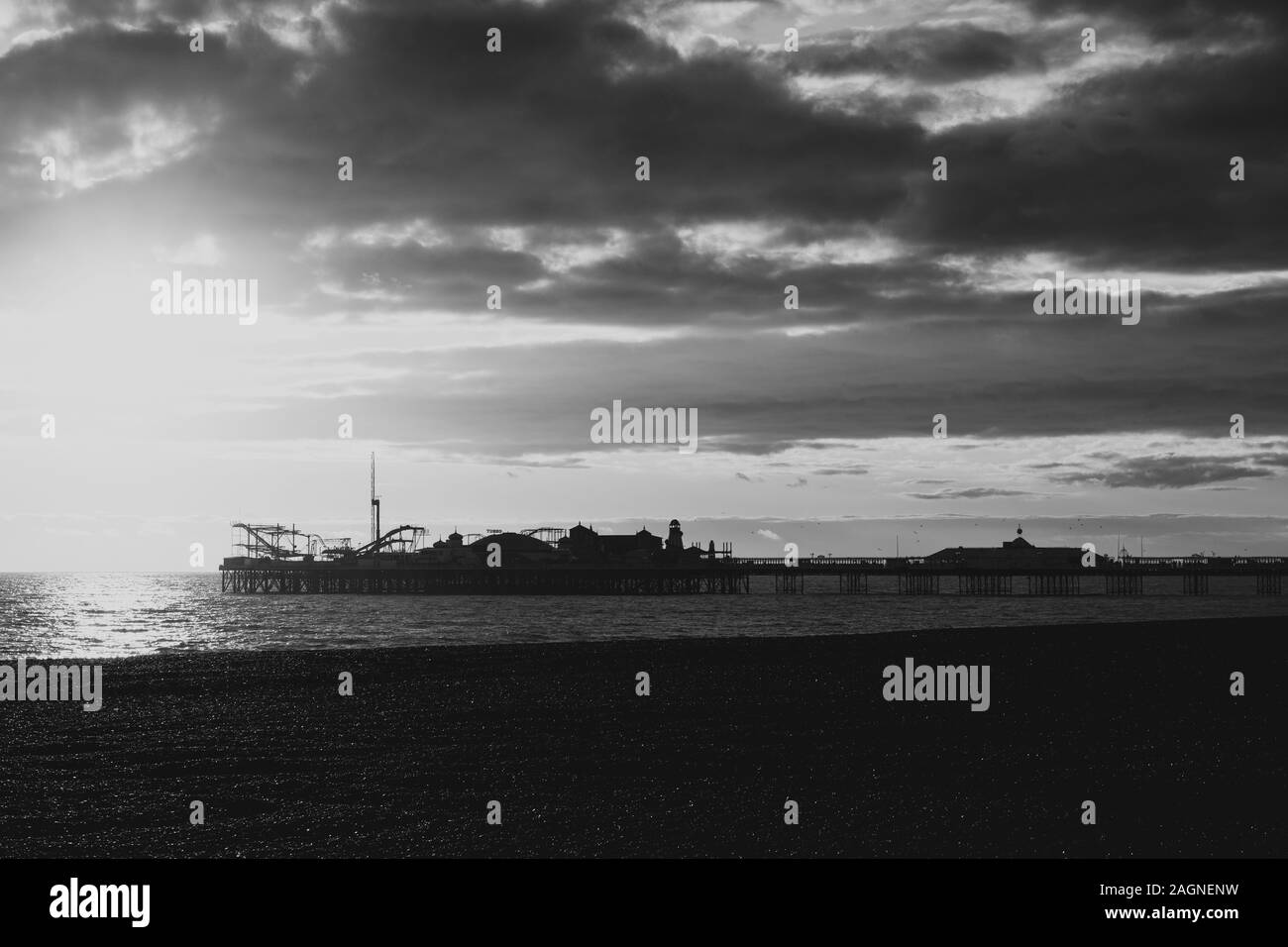 BRIGHTON, Großbritannien - 03.November 2019: Reste von Brighton Pier. Die Silhouetten, die laufen am Strand, Wellen erzeugen Wellen am Ufer, Ocean Spa Stockfoto
