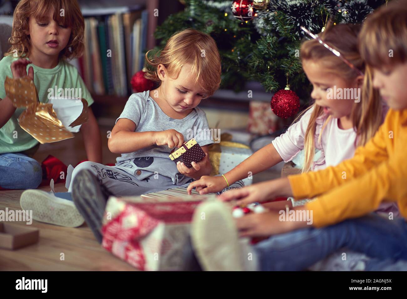 Kleine Kinder Eröffnung Weihnachten Geschenk überrascht. Stockfoto