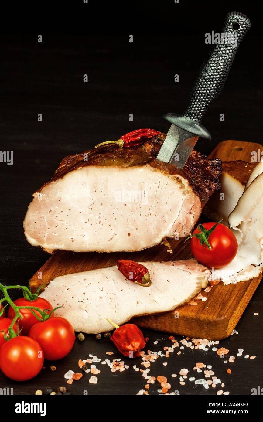 Geräuchertes Fleisch auf eine Küche. Hausgemachte geräuchertes Schweinefleisch mit Gemüse. Ungesunde Lebensmittel. Der fleischverarbeitung. Zarte Delikatesse. Stockfoto
