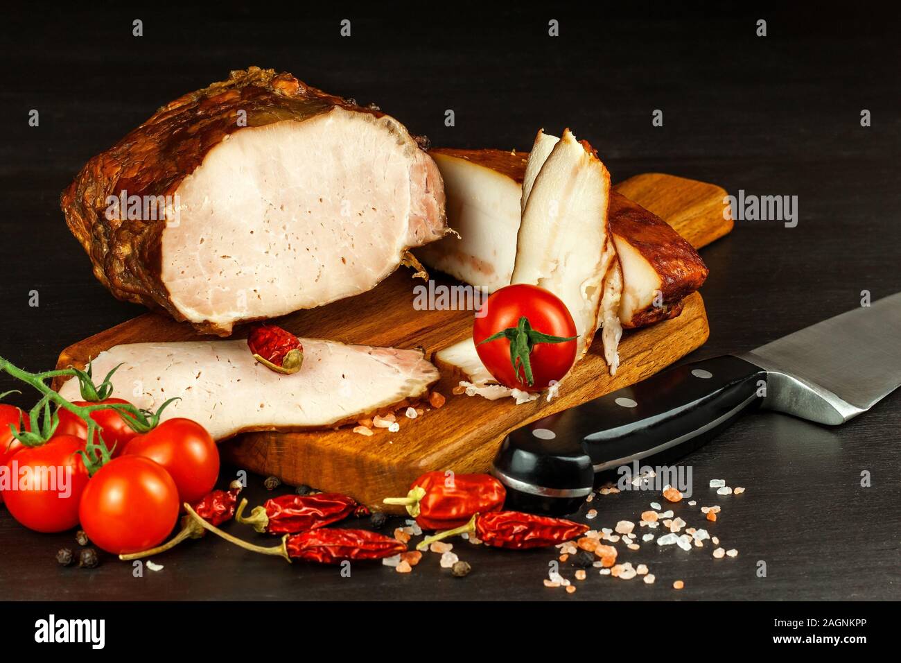 Geräuchertes Fleisch auf eine Küche. Hausgemachte geräuchertes Schweinefleisch mit Gemüse. Ungesunde Lebensmittel. Der fleischverarbeitung. Zarte Delikatesse. Stockfoto