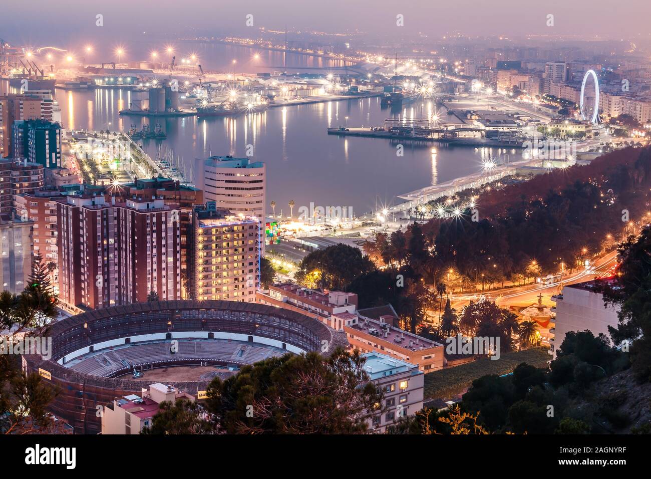 Panoramablick von Málaga an der spanischen Mittelmeerküste in der Nacht. Blick auf die Stadt an der Costa del Sol mit beleuchteten Hafen, Wohngebiet bauen Stockfoto