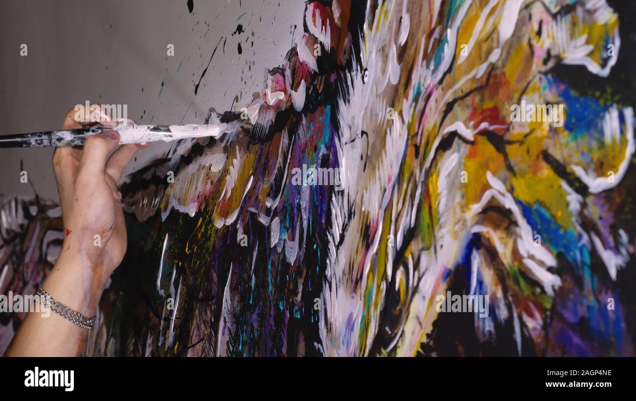 Künstler Designer zieht ein Adler an der Wand. Handwerker Dekorateur malt ein Bild mit Acryl öl Farbe Pinsel. Close-up dunkle Magie filmischen Look. Stockfoto