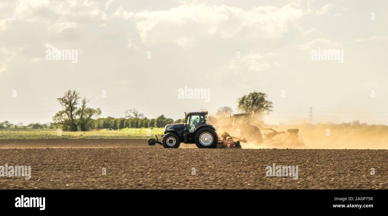 Ein Traktor gesehen Pflügen eines Feldes in Vorbereitung für den Anbau von Kulturpflanzen. Stockfoto