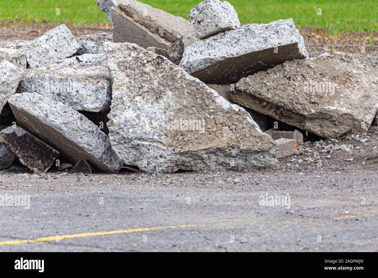 Fragmente von Asphalt und Beton sind auf dem Boden in einem Parkplatz angehäuft. Der Stein Scherben wurden ausgegraben und zerrissen aus dem Los. Stockfoto