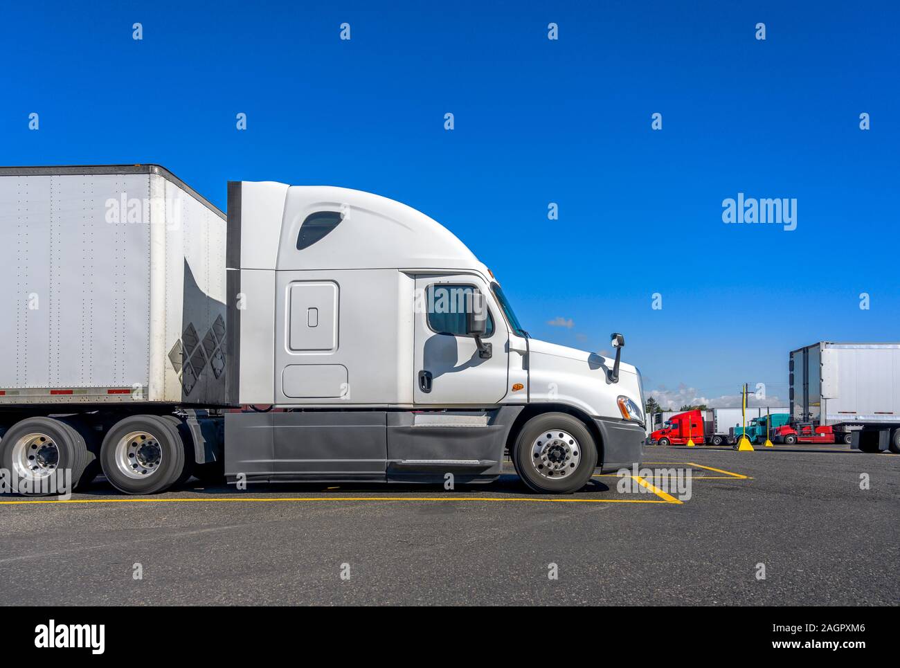 Langstrecke Big Rig white Semi Truck Traktor auf LKW-Parkplatz gegenüber anderen semi Trucks in Reihe stehen für LKW-Fahrer Rest warten f Stockfoto