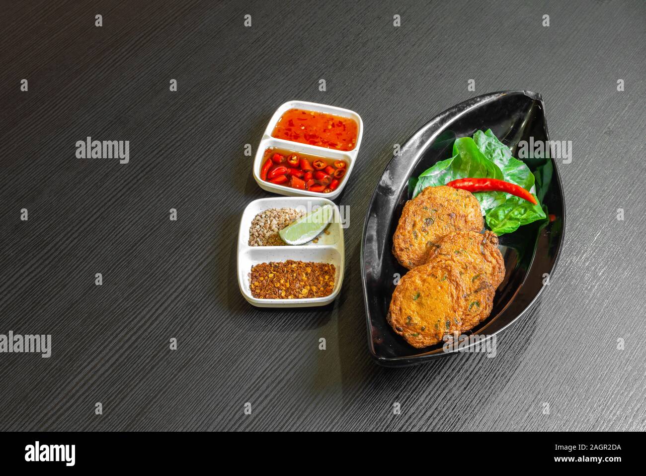 Würzig gebratener Fisch Kuchen, (Tod Mun Pla), eine traditionelle Thailand Vorspeise ist mit frischem Fisch Paste, lange Bohnen, rote Curry Paste und Kaffernlimette leav Stockfoto
