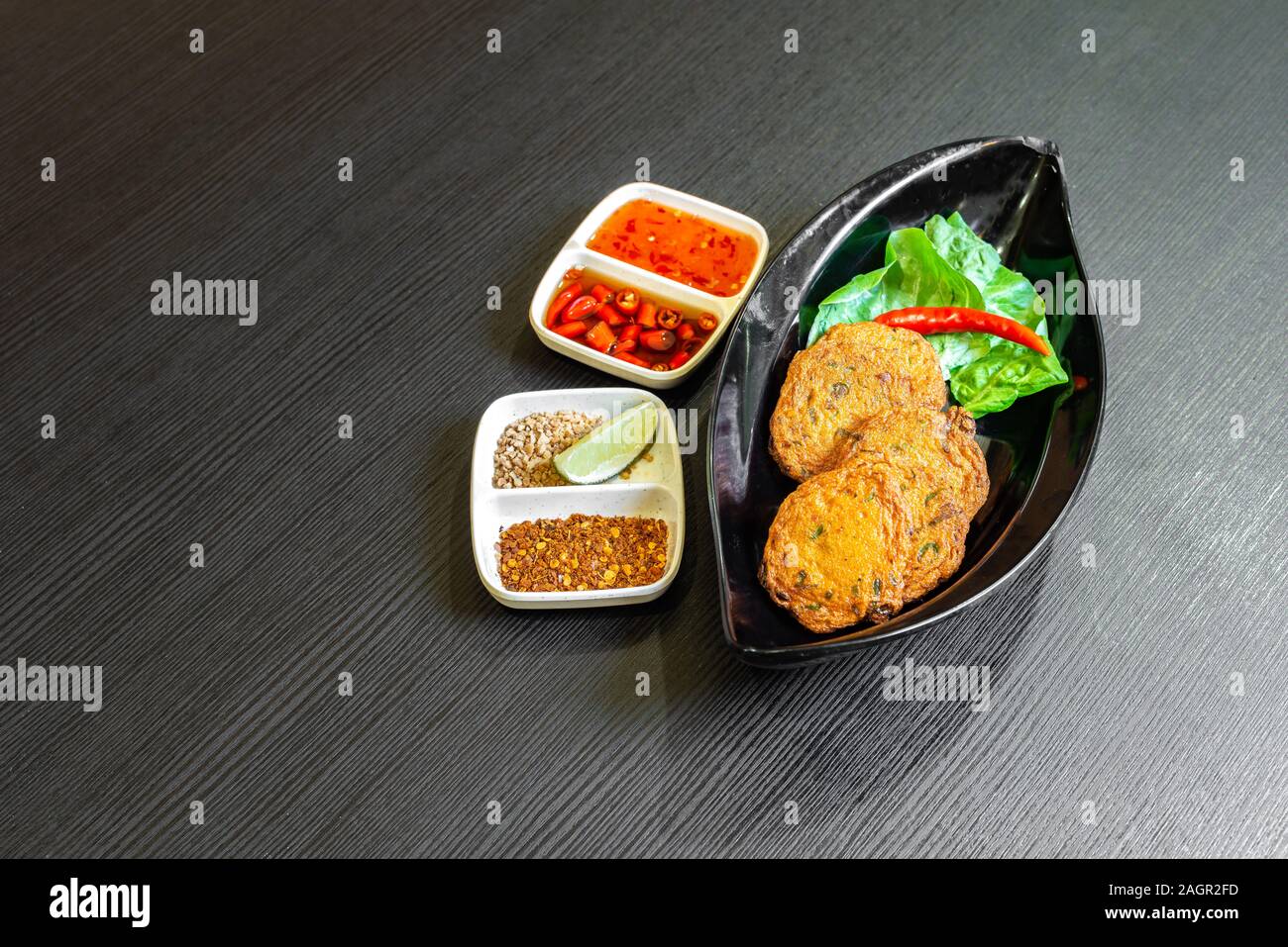 Würzig gebratener Fisch Kuchen, (Tod Mun Pla), eine traditionelle Thailand Vorspeise ist mit frischem Fisch Paste, lange Bohnen, rote Curry Paste und Kaffernlimette leav Stockfoto