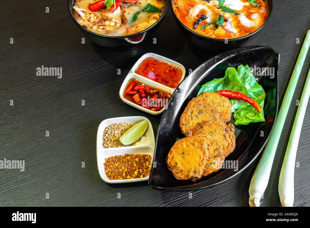 Würzig gebratener Fisch Kuchen, (Tod Mun Pla), eine traditionelle Thailand Vorspeise ist mit frischem Fisch Paste, lange Bohnen, rote Curry Paste und Kaffernlimette leav Stockfoto